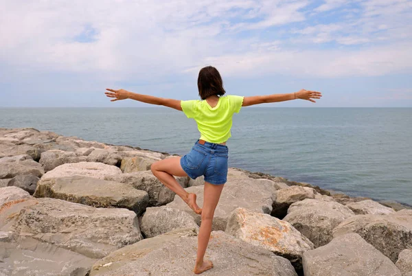 Young Slender Girl Rocks Dike Sea While Performing Gymnastic Exercises — Stockfoto