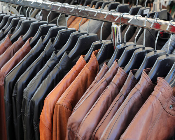 leather jackets for sale in the leather goods shop attached to hangers of various colors and sizes