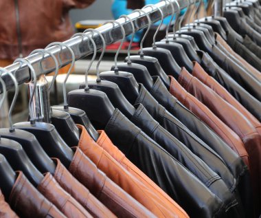 Deri mağazasında satılık bir sürü deri ceket var. Çeşitli boylarda ve renklerde askılara bağlı.