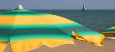 Sarı ve yeşil şemsiyeler Sahilde insanlar olmadan güneş