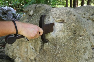 Kral Arthur 'un efsanesindeki gibi taştaki kılıç ve şövalyenin eli.