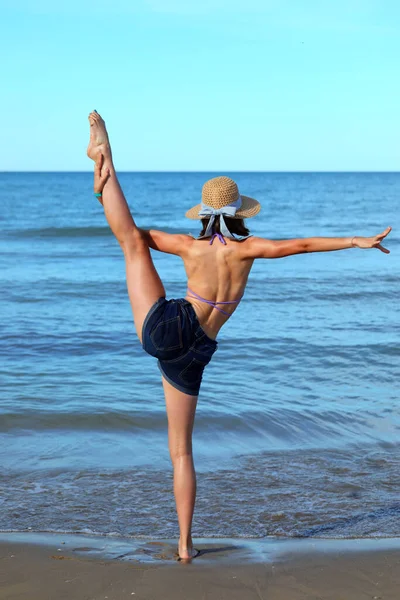 Девушка Соломенной Шляпе Моря Выполняет Сложные Упражнения Гимнастике — стоковое фото