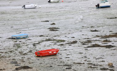 beached red boat on the beach at low tide with no people