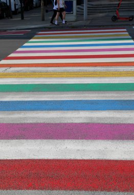 large pedestrian crossing with lines of many rainbow colors in the city