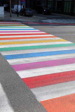 large pedestrian crossing with lines of many rainbow colors on the street
