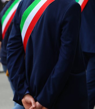 elegant Italian mayor during the election rally with the green white and red tricolor band