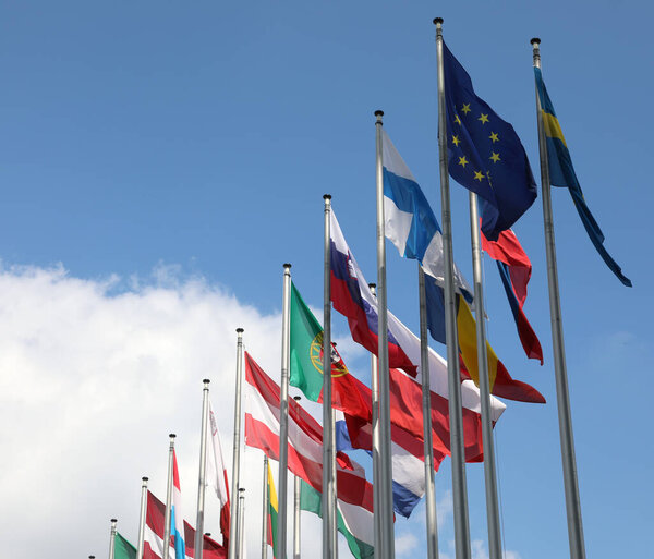 флаг Европы и другие флаги на фоне голубого неба и облаков