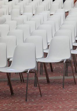 white plastic chairs with metal legs without the people before the show starts