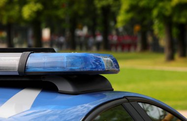 blue flashing of the siren of the police car during a check in the public park of the city