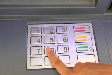 hand of people typing secret code on numeric keypad without being seen