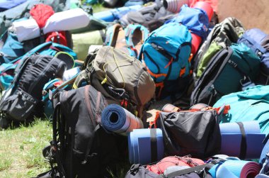 many backpacks and backpacks with sleeping bags during the boyscout summer camp without people