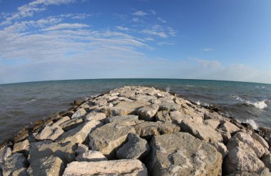 seascape with sea and rocks in summer without people and blue sky with few clouds