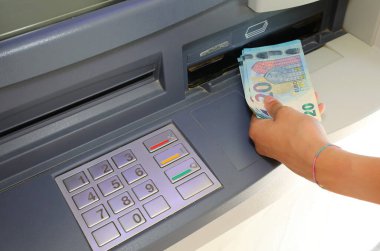 hand of the person who withdraws money in european twenty euro banknotes in the atm automatic teller machine