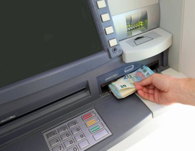 hand of the person who withdraws money in european twenty euro banknotes in the atm automatic teller machine