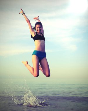 Gülümseyen, mutlu, narin bir kız. Deniz kenarında eski tonu olan.