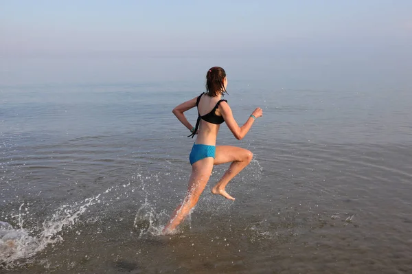 Wysportowana Młoda Dziewczyna Biegnie Szybko Wodzie Nad Morzem Podczas Codziennego — Zdjęcie stockowe