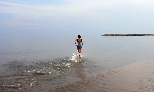 Wysportowana Dziewczyna Szybko Biegająca Wodzie Nad Morzem Podczas Wieczornego Codziennego — Zdjęcie stockowe