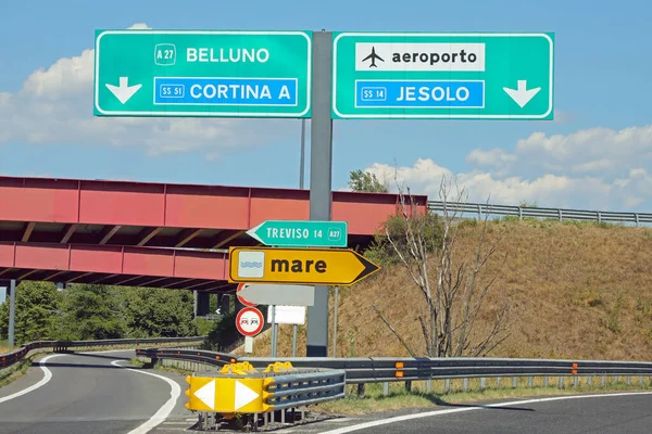 motorway junction with the Italian localities of Belluno Cortina or Jesolo or Treviso and yellow arrow with text MARE which means SEA