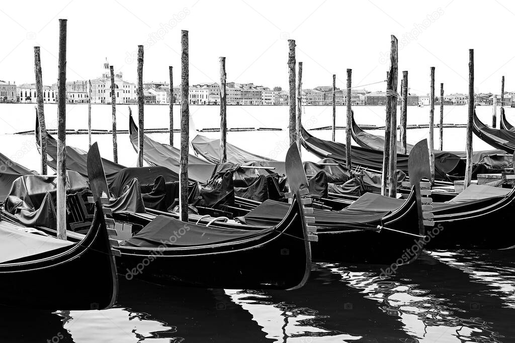 moored gondolas with the bow with the famous shape of the symbol of Venice with effect in black and white without tourists