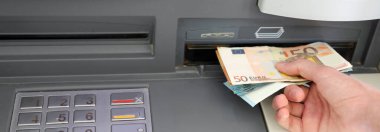 Bir ATM 'den Avrupa para banknotları alan genç kişi