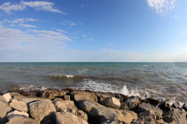 Yazın deniz ve kayalarla kaplı deniz manzarası ve bulutsuz mavi gökyüzü.