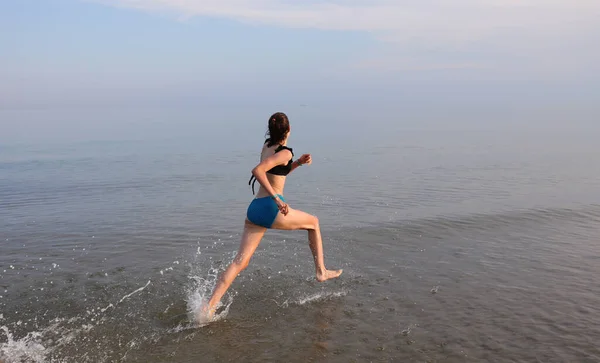 Młoda Dziewczyna Biegająca Wodzie Morskiej Latem Podczas Treningu Sportowego — Zdjęcie stockowe