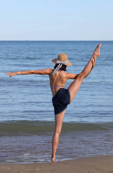 Young Slender Girl Straw Hat Does Gymnastic Exercises Sea Summer — Foto de Stock