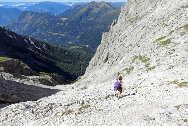 若い女性がイタリアの淡いグループと呼ばれる山脈のヨーロッパアルプスのドロマイトの道を歩く — ストック写真