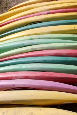 Nehir kıyısında insanlar olmadan eğitimden önce çeşitli renklerde kanolar var.