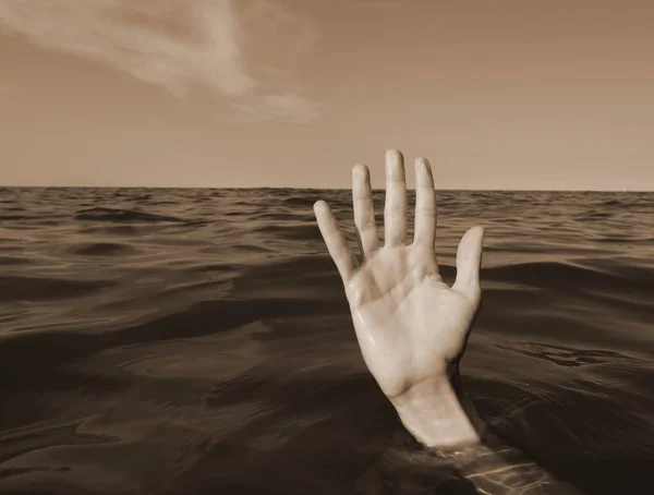 hand on the water of sea  of a person who is drowning and seeks help  with sepia toned