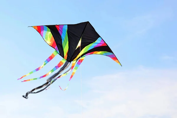 Zwarte Vlieger Met Kleurrijke Strepen Vliegt Blauwe Lucht Bevestigd Aan — Stockfoto