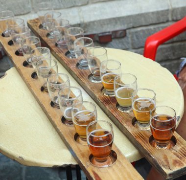 Bira fabrikasında bira servisi yapılan masalarda bir sürü bardak var.
