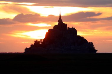 Turuncu kırmızı renkleri ve antik manastırın siluetiyle inanılmaz bir gün batımı.