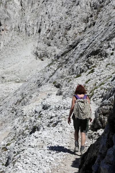 若い女性がイタリアの淡いグループと呼ばれる山脈のヨーロッパアルプスのドロマイトの道を歩く — ストック写真
