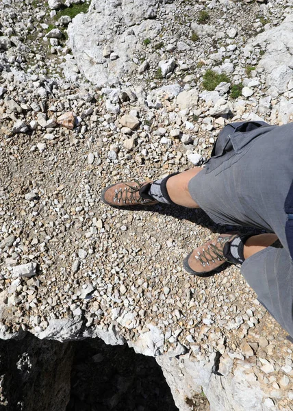 mountain boots at the foot of the hiker during the walk on the stony mountain path