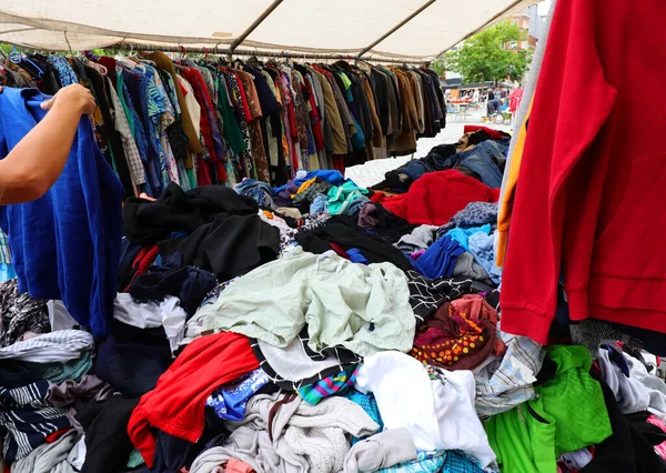 used clothes in the outdoor flea market stall with many bargains