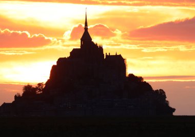 Günbatımında Fransa 'daki Mont Saint Michel Manastırı' nın kilise ve çan kulesinin nefes kesici silueti.