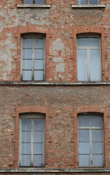 古い工業ビルの赤レンガと古い剥離窓のあるファサード — ストック写真