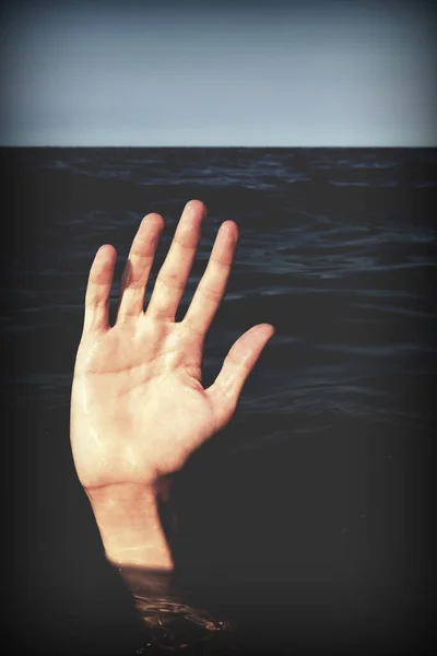 hand on the water of sea  of a person who is drowning and seeks help