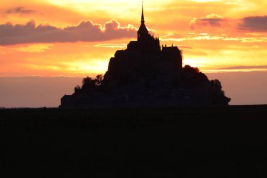 Günbatımında Fransa 'daki Mont Saint Michel Manastırı' nın kilise ve çan kulesinin nefes kesici silueti.