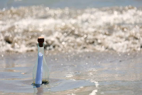 clear glass bottle with secret message inside by the sea