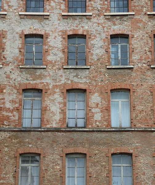 旧工业建筑物的有红砖和旧剥皮窗的立面 — 图库照片