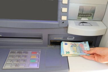 Avrupa Euro 20 'lik banknotları bankamatik makinesinden alan kişi