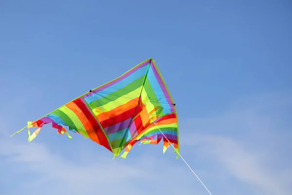 Красочный Воздушный Змей Полосками Различных Цветов Радуги Летящей Голубому Небу — стоковое фото