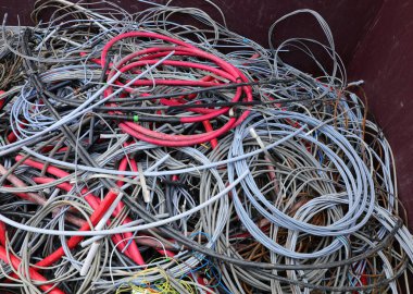 Elektrik kabloları, endüstriyel atık sahasında bakır elde etmek için konteynır üzerinde çalışır.