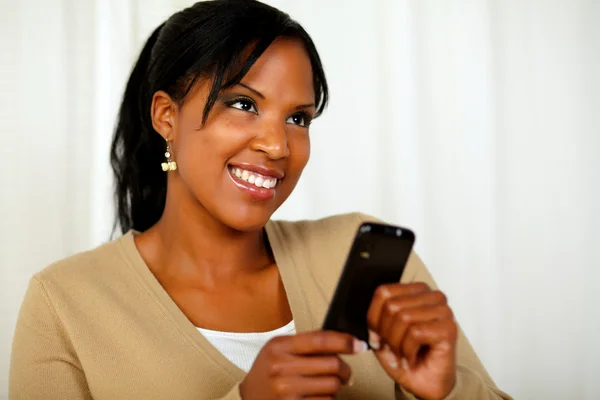 Leende kvinna skickar ett meddelande till mobiltelefon — Stockfoto