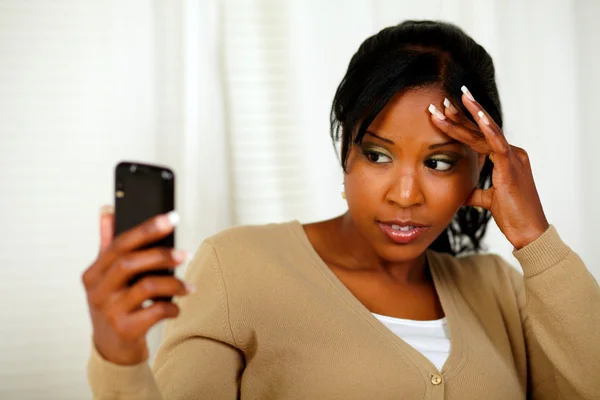 Junge Frau mit Kopfschmerzen beim Lesen einer Nachricht — Stockfoto