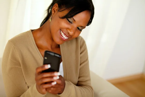 Happy svart kvinna skicka ett meddelande via mobiltelefon — Stockfoto