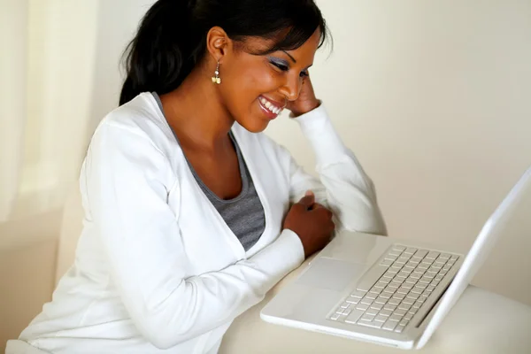 노트북 화면에서 읽기의 젊은 여성이 웃는 개 — 스톡 사진