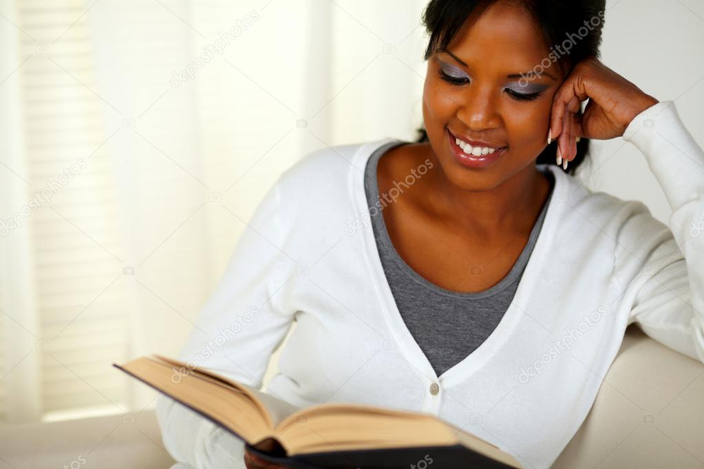 Smiling black woman reading a book